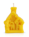 Christmas beeswax candle in the shape of a house on a white background