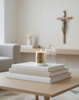 Living room with a coffee table featuring books and a candle, a couch in the background.