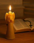 lit up angel beeswax candle with bible and rosary