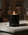 Candle in a black container with 'Live Your Faith' branding on a vanity lit up with the words "I thirst"