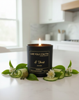 Candle in a black container with 'Live Your Faith' branding on a kitchen counter with the words "I Thirst"