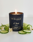 Candle in a black container with 'Live Your Faith' branding on a white background