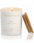 White candle with the words "Jesus I trust in you" made by Live Your Faith Catholic on a white background with a flame