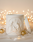 Decorative white nativity candle jar with relief design on a christmas background