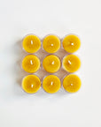 Nine yellow beeswax candles in a 3x3 grid on a white background