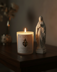 Candle with 'Live Your Faith' label and a statue of Virgin Mary on a wooden surface.