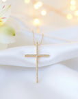 Gold Cross Necklace on a white satin fabric