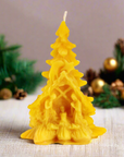 100% beeswax Christmas tree candle with nativity scene in a table with Christmas decoration. Prayer candle