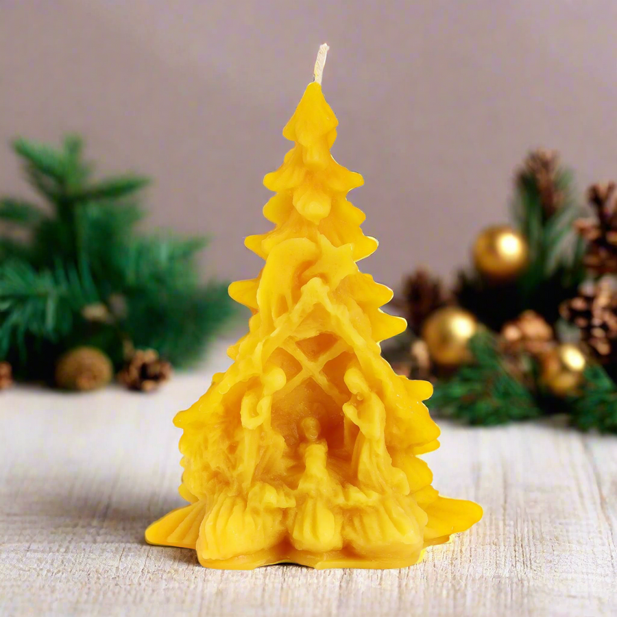 100% beeswax Christmas tree candle with nativity scene in a table with Christmas decoration. Prayer candle