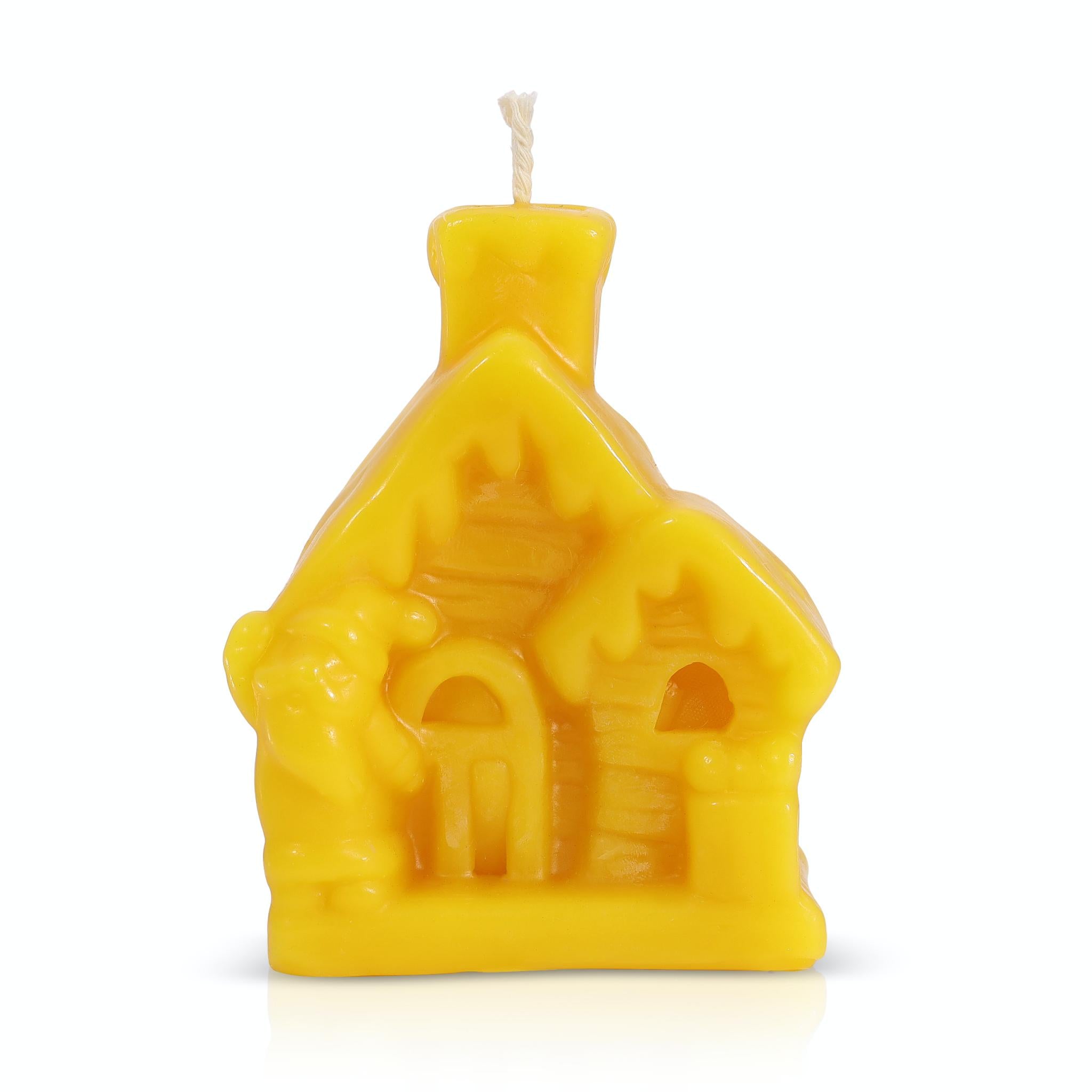 Christmas beeswax candle in the shape of a house on a white background