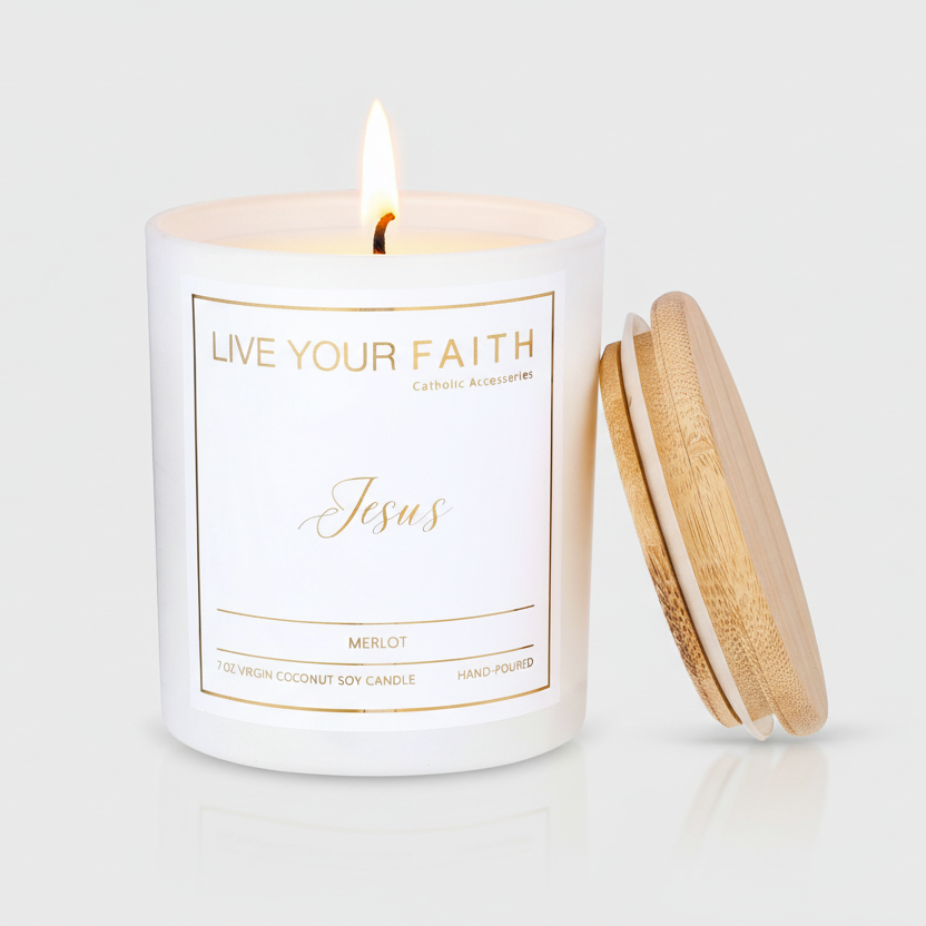 Hand-poured white glass jar candle labeled Jesus Merlot with a burning wick and a bamboo lid leaning against the side.