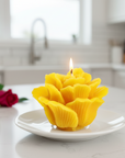 small beeswax candle shaped as a rosette with a red rose on a kitchen counter