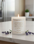 Candle with a prayer from St. Therese of Avila on a marble surface with lavender flowers