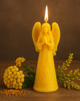 Lit up beeswax praying angel candle with yellow flowers