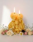 Pure beeswax candles shaped like a Holy family with flowers and a bee on a light background