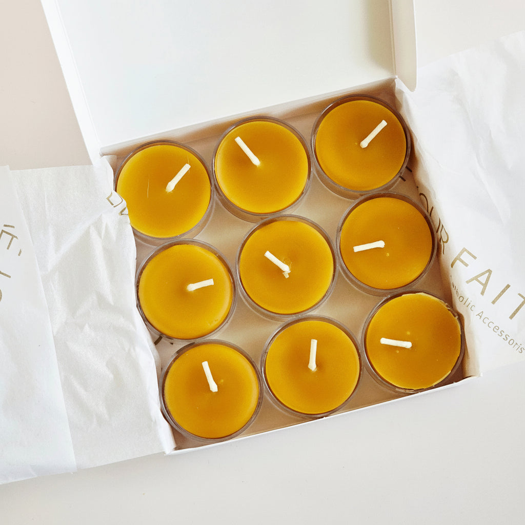 Nine yellow  beeswax candles in a cardboard box on a white background