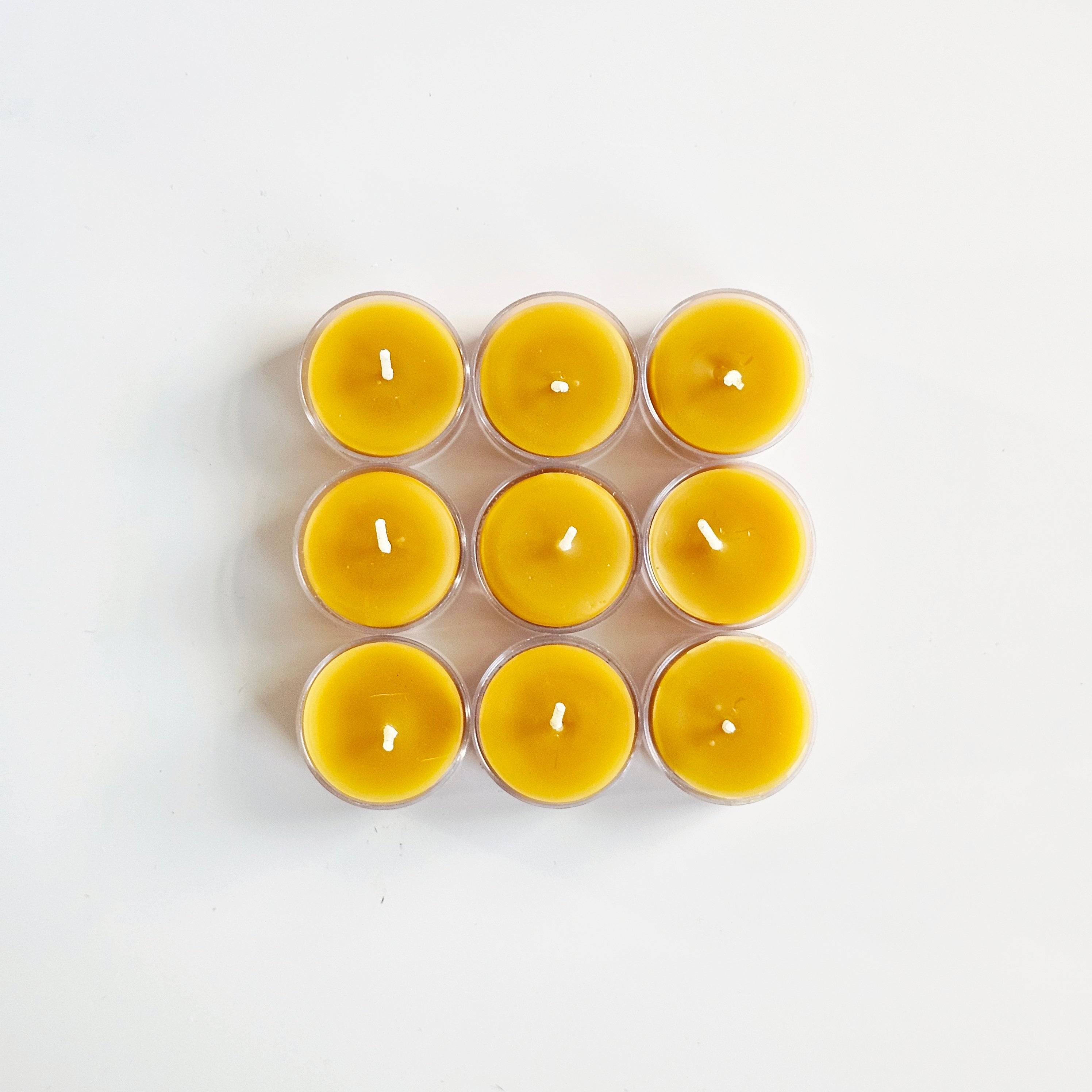 Nine yellow beeswax candles in a 3x3 grid on a white background