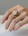 Gold ring with a decorative design on a white surface