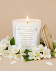 Candle with the serenity prayer surrounded by white jasmine flowers on a beige background