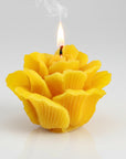 Yellow beeswax flower-shaped candle on a white background