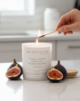 Candle with the surrender novena prayer being lit with figs on a kitchen counter.