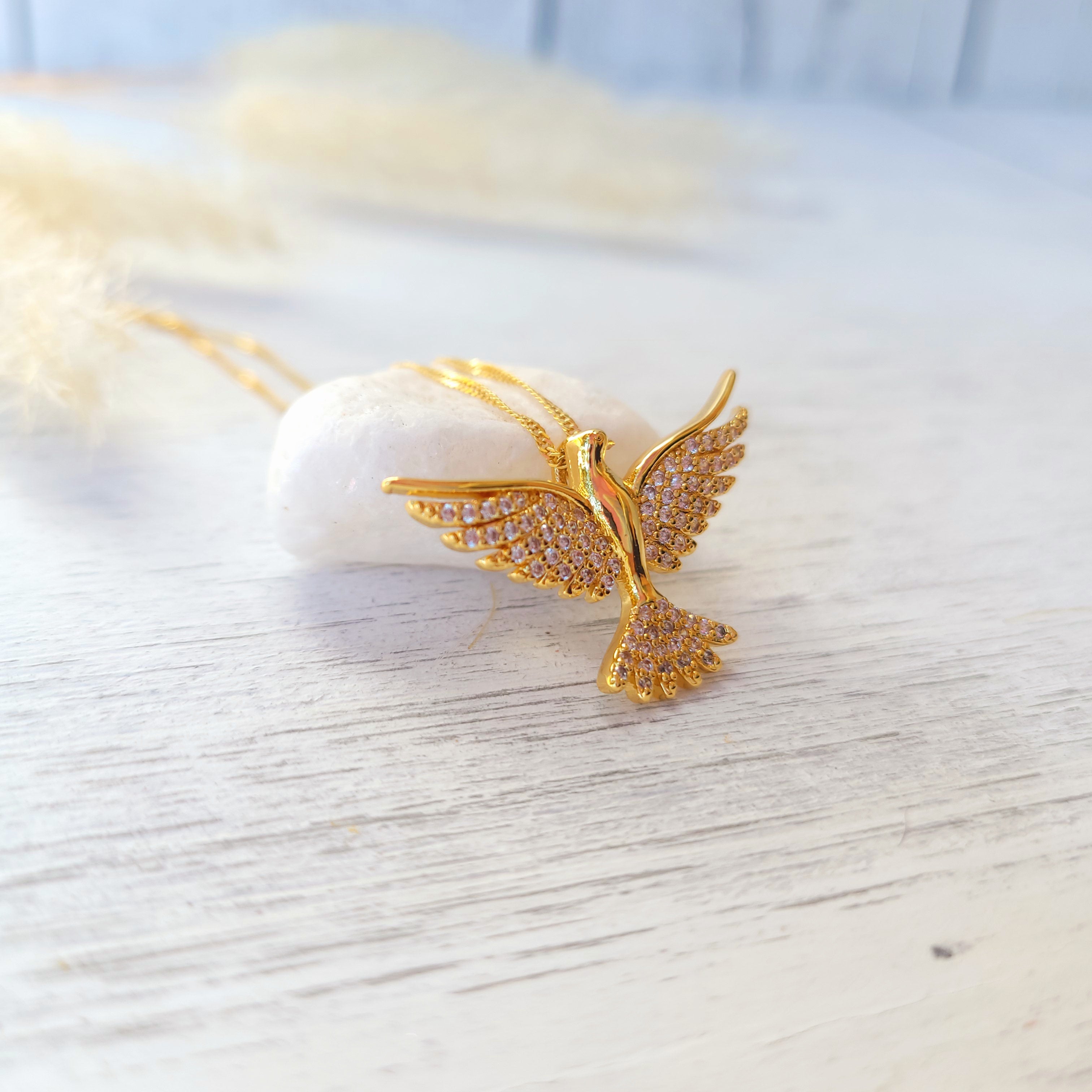 cubic zirconia catholic dove necklace on white surface